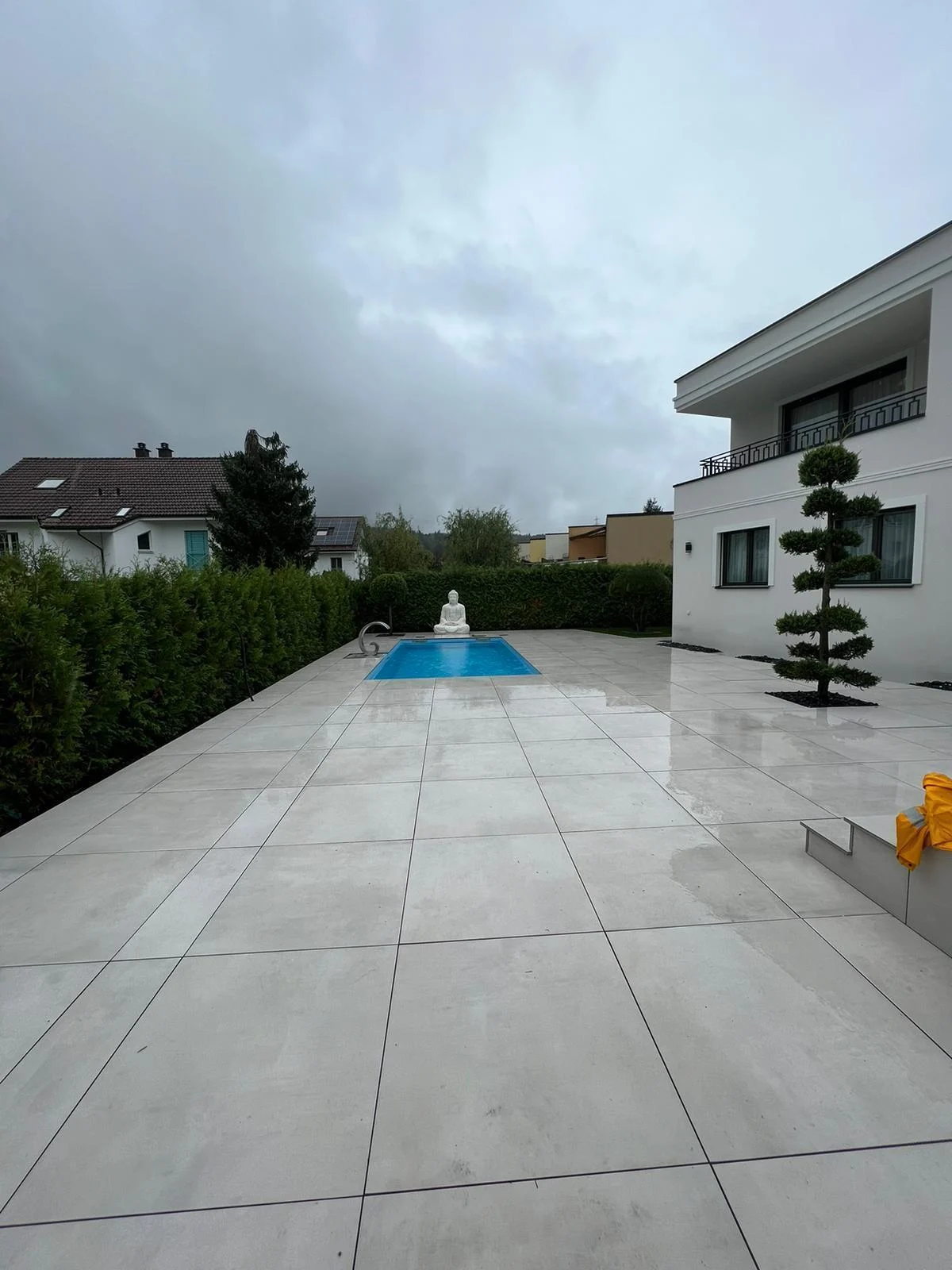 Weite Plattenterrasse mit kleinem Pool