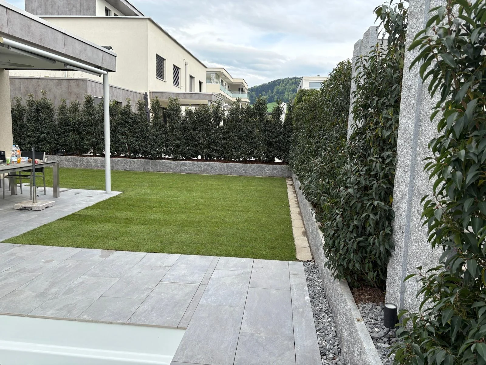 Rasenfläche zwischen Terrasse und Sichtschutz