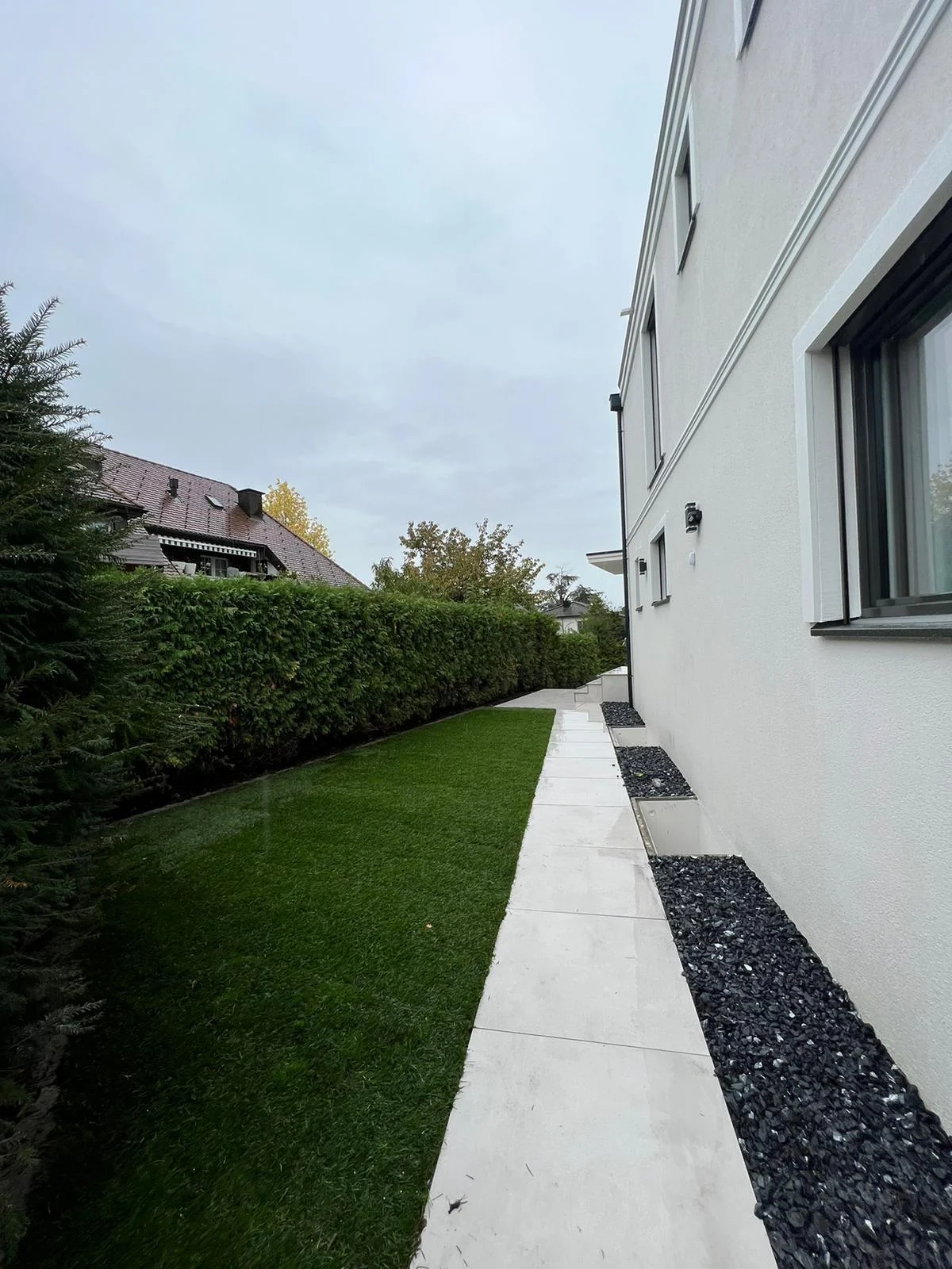 Plattenweg zwischen Rasen und Haus