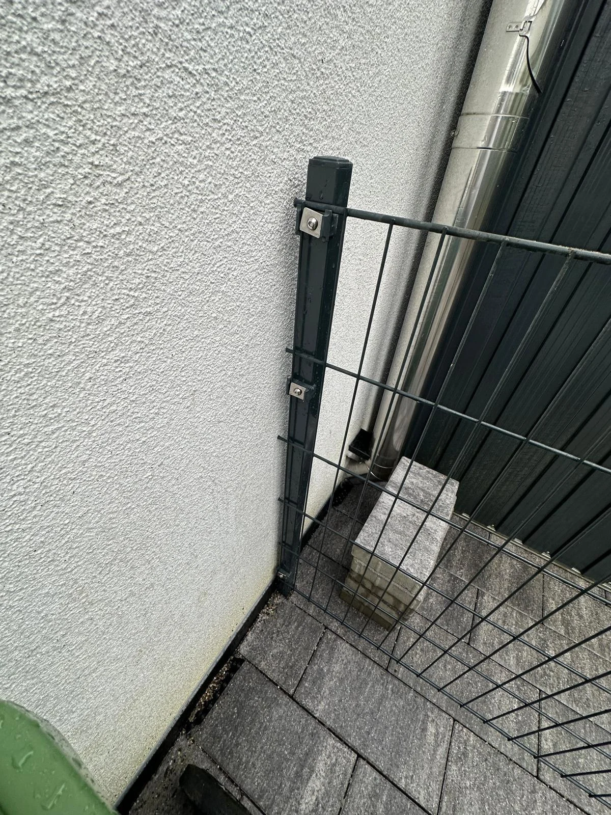 Gitterzaun am gepflasterten Hausanschluss