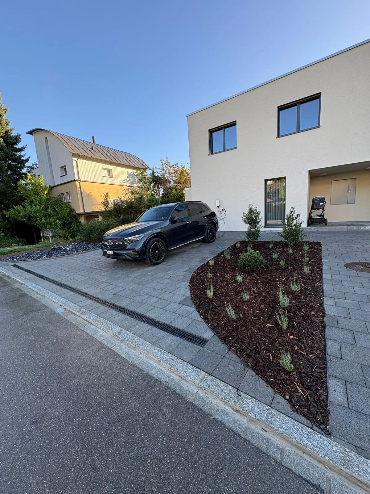 Gepflasterte Einfahrt mit geschwungenem Pflanzbeet