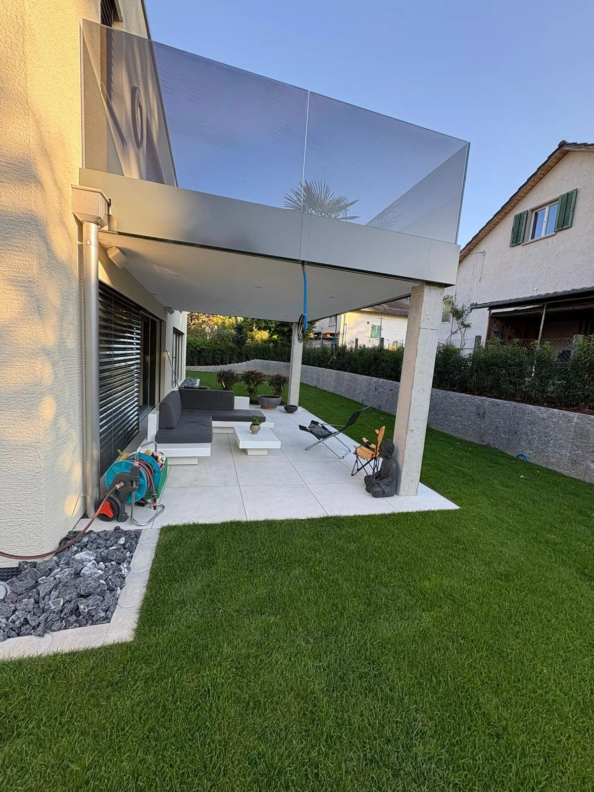 Überdachte Terrasse mit angrenzendem Rasen